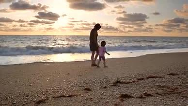 唯美夕阳海滩妈妈和女儿散步视频的预览图